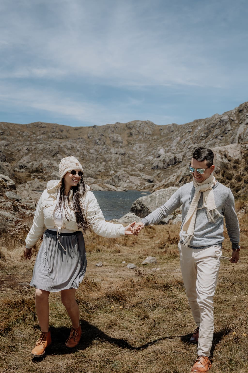 Janner y Marcela caminando de la mano junto a una laguna del páramo